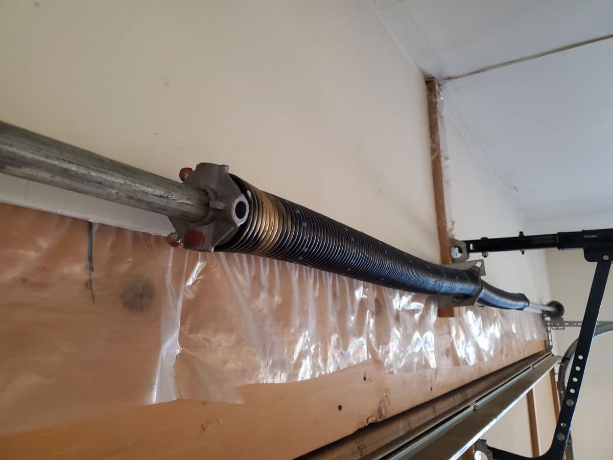 Technician replacing a garage door torsion spring